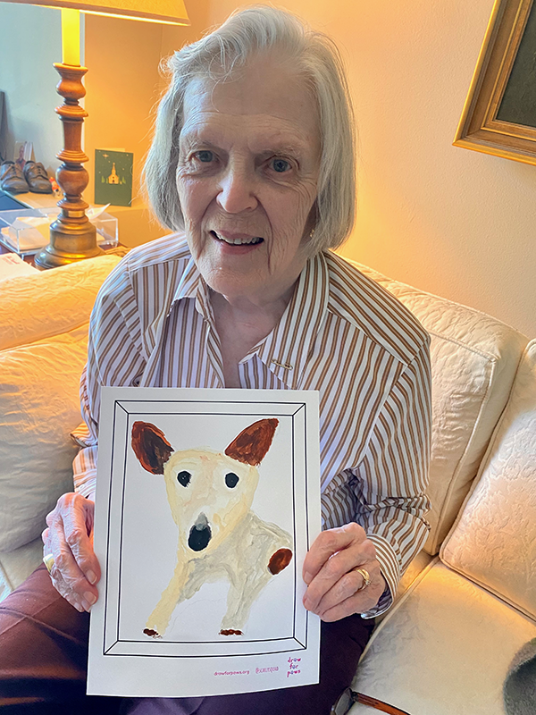 A community member proudly displaying her beautiful painting